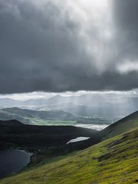 Mountain range with two visible lakes.  A heavy cloud cover casts shadows Stock Photos