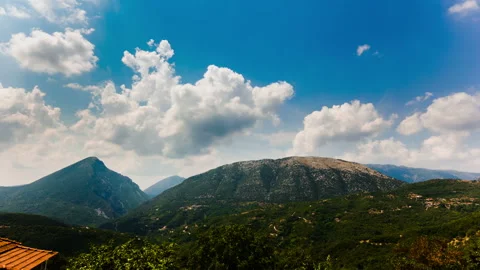 Mountain Range Under Towering Clouds and Blue Sky – 2K 30fps Stock Footage 322211808
