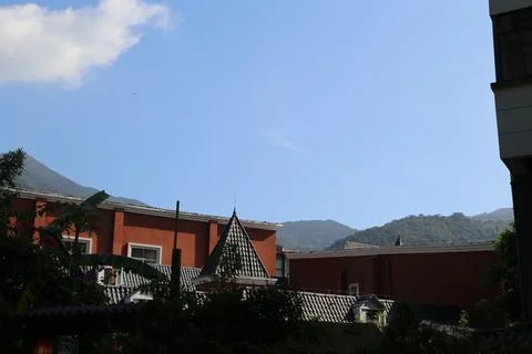 A mountain range is visible in the background of a city with a red building Stock Photos