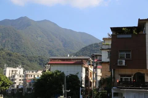 A mountain range is visible in the background of a city with many buildings Stock Photos