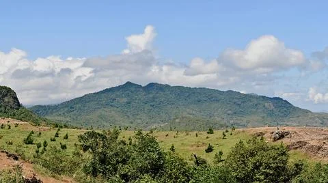 A mountain range is visible in the distance, with a clear blue sky above Stock Photos