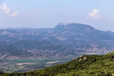 A mountain range is visible in the distance with a clear blue sky on the is.. Stock Photos