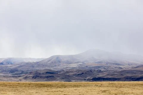 A mountain range is visible in the distance, with a cloudy sky overhead Stock Photos