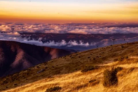 Mountain range with visible silhouettes through the morning colorful fog.Tarc Stock Photos