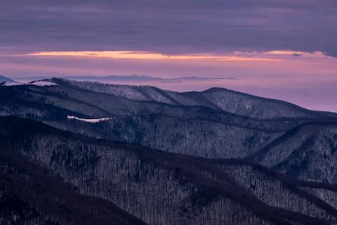 Mountain range with visible silhouettes through the morning colorful fog.Tarc Stock Photos