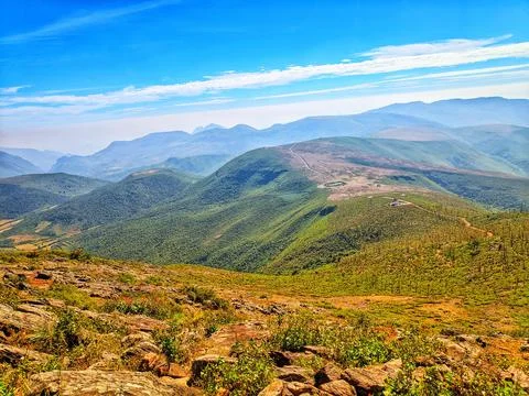 Mountain range with visible silhouettes through the morning colorful fog. Stock Photos