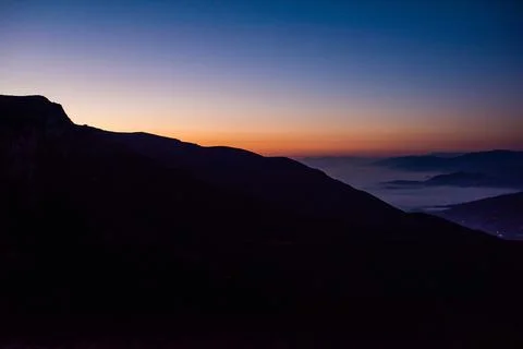 Mountain range with visible silhouettes through the morning colorful fog Stock-Fotos