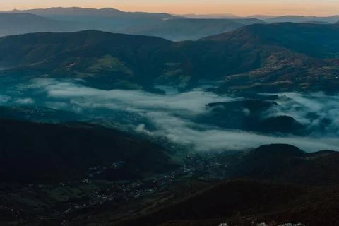 Mountain range with visible silhouettes through the morning colorful fog Stock-Fotos