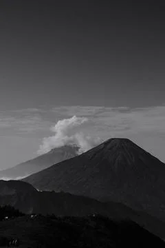 A mountain range with a volcano in the background 스톡 사진