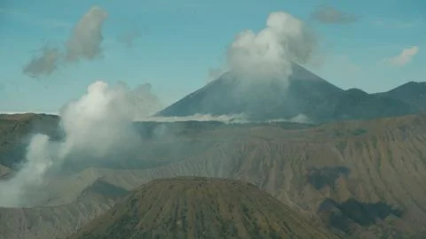 A mountain range with a volcano in the background Stock Photos