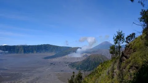 A mountain range with a volcano in the distance Photos