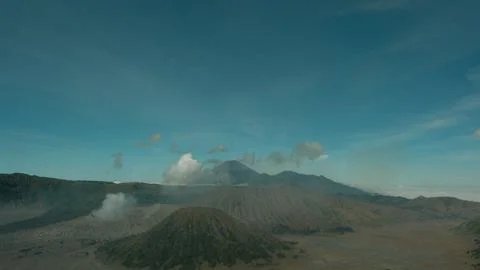 A mountain range with a volcano in the middle Stock Photos