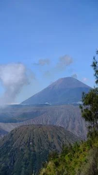 A mountain range with a volcano in the middle Stock Photos