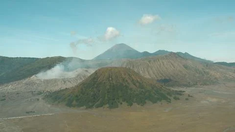 A mountain range with a volcano in the middle Stock Photos