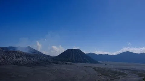 A mountain range with a volcano in the middle Stock Photos