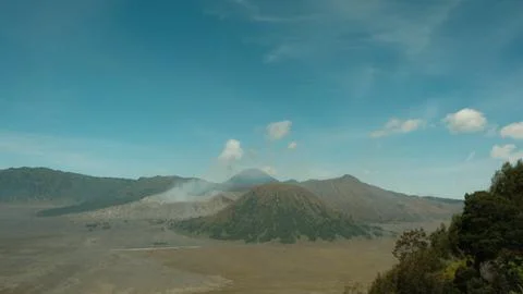 A mountain range with a volcano in the middle Stock Photos