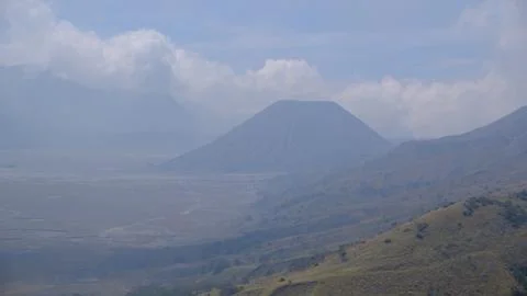 A mountain range with a volcano in the middle 写真素材