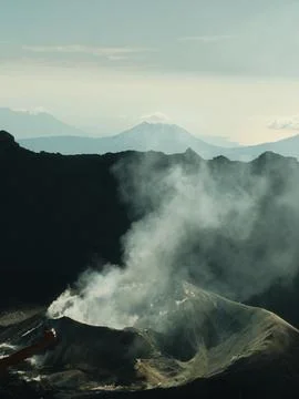 A mountain range with a volcano in the middle Stock-Fotos