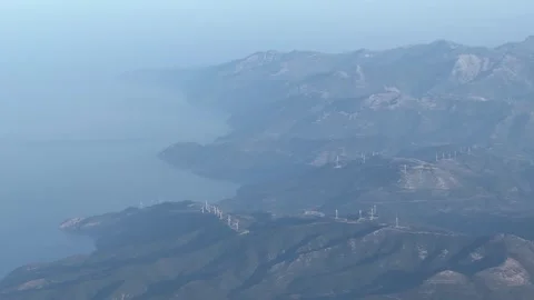 Mountain range with water in background under hazy sky Video stock 268486733