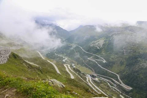 A mountain range with a winding road that is covered in fog Foto stock