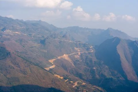 Mountain range with winding road through valleys Stock Photos