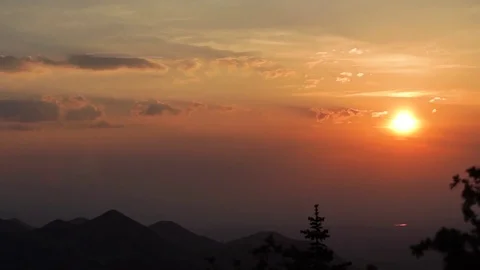 Mountain ranges and orange sunlight spread over during sunset Stock Footage