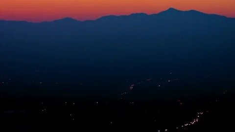 Mountain ranges and vehicles moving on the street at night, Time-lapse Stock Footage 77764982