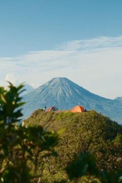 A mountain with a red tent on top Stock Photos