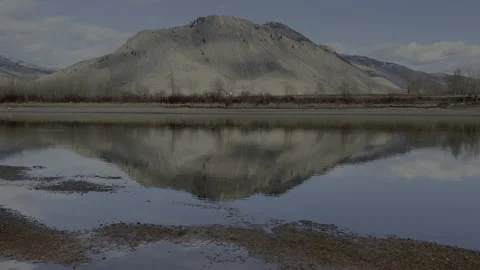 Mountain reflected in river in afternoon light, 4k Stock Footage 233749661