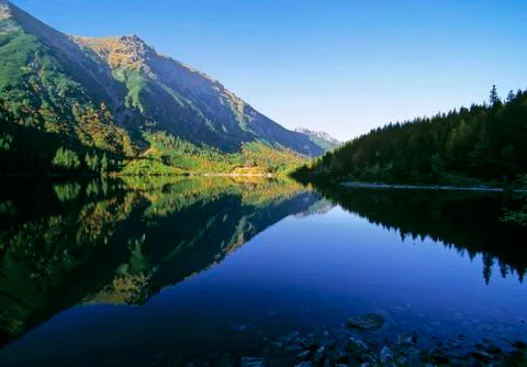 Mountain reflection in motionless lake Stock Photos