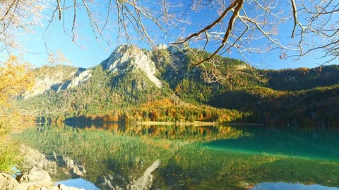 Mountain reflection on still water with warm autumn tones and Bavarian forest Stock Footage 309094732