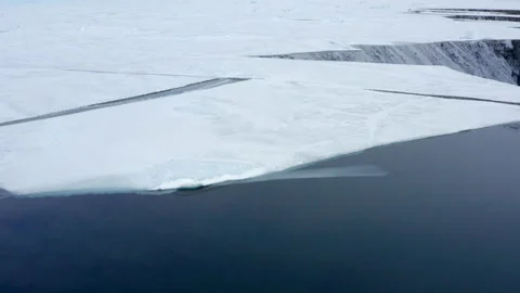 Mountain reflection through Sea Ice and Ice floes. South Greenland. Stock Footage 168674267