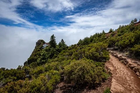 Mountain refuge surrounded by clouds and dramatic cliffs along the breathtaki Stock-Fotos