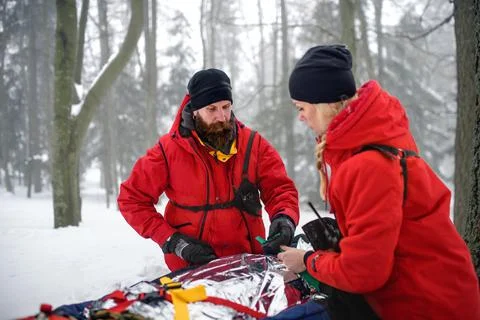 Mountain rescue service provide operation outdoors in winter in forest, injured Stock Photos