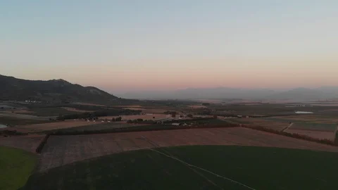 Mountain reveal basking in Sunset over agricultural land 動画素材 126344675