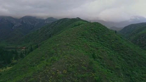 Mountain ridge and valley dam beneath low cloud, cinematic aerial Stock Footage 342334706