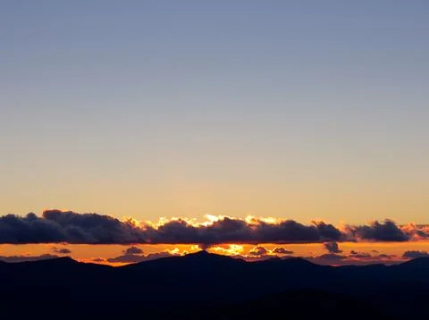 Mountain ridge at sunset with clouds Stock Photos
