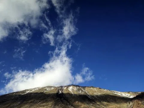 Mountain ridge under dramatic cloudy blue sky 库存照片