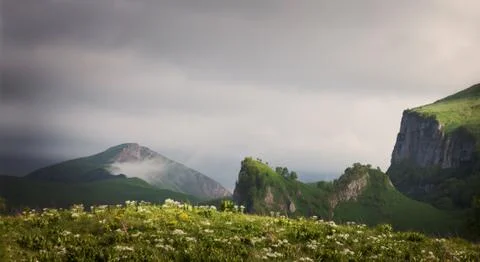 Mountain ridges at against the sky with clouds Stock Photos