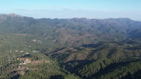 Mountain ridges and deep gorge across green valley with distant village view Stock Footage 344094741