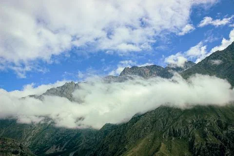 Mountain ridges with clouds and bright blue sky Stock Photos