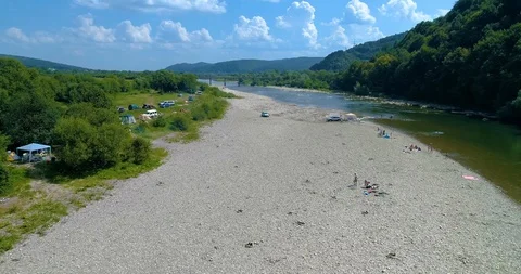 Mountain river and stone thresholds. people rest on the shore and on an Stock Footage 98246425