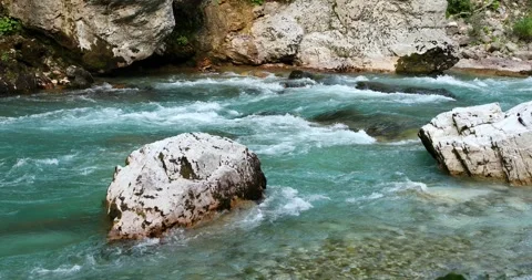 Mountain river with azure water flows among large stones Stock Footage 247701089