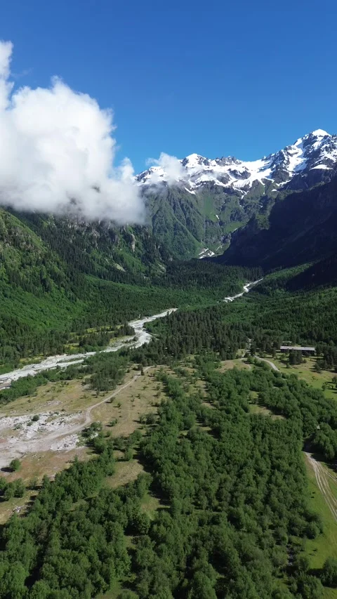 Mountain River Basin Enclosed By Giant Peaks Vertical Drone 4K RAW Stock Footage 339736090