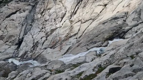 Mountain river born from the rhone glacier melting, flowing rapidly over Stock Footage 340920679