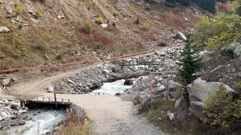 Mountain River with Bridge and Scenic Peaks Stock Footage 337473400