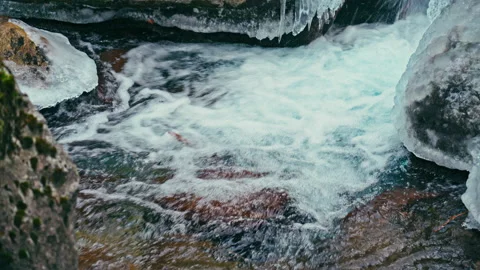 Mountain river with clear water with ice and foam, icicles on the rocks Stock Footage 136847517