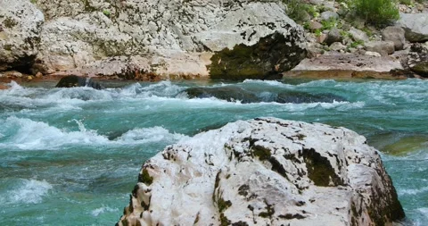 Mountain river with emerald water flows among large stones Stock Footage 247509303