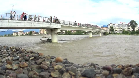 A mountain river with a fast current near the bridge Stock Footage 256675928