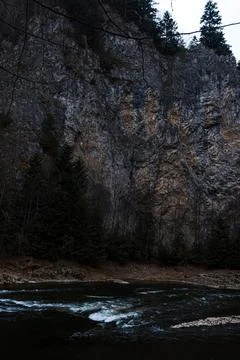 Mountain River Flowing Beneath Towering Limestone Cliffs Fotos de archivo